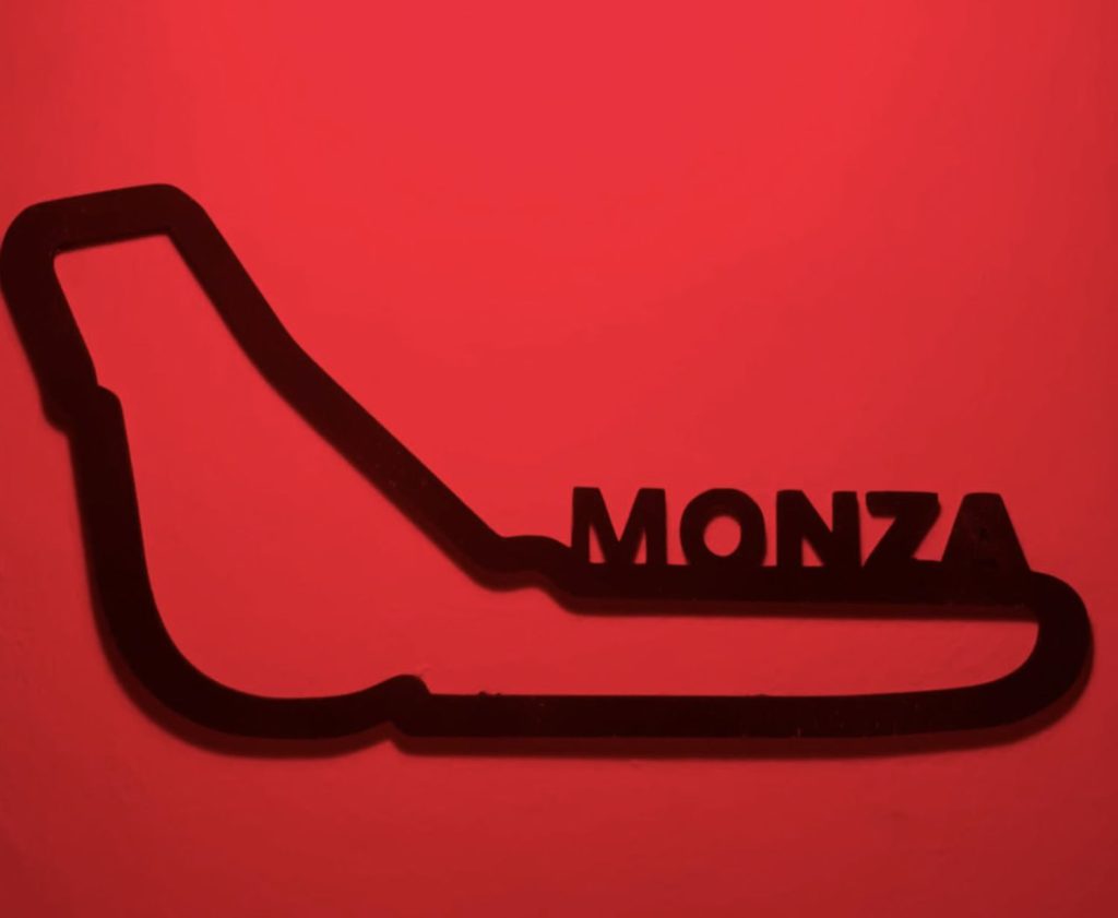 Circuito di formula 1 di Monza, in plexiglass nero tagliato a laser. fissato su muro bianco. Primo piano con illuminazione rossa